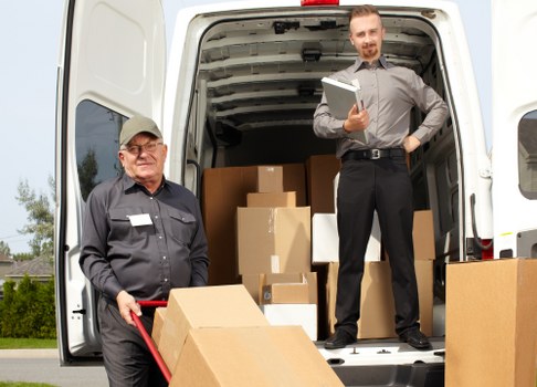 Removal team loading furniture and boxes for urgent moving service