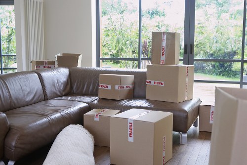 Furniture being carried through a residential apartment entrance in Colliers Wood